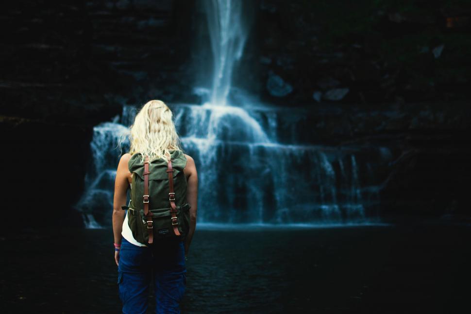 Free Image of Woman Standing in Front of a Waterfall 