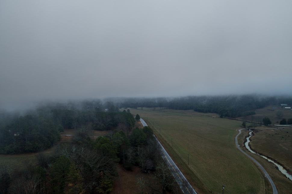 Free Image of Plane Flying Over Foggy Field 