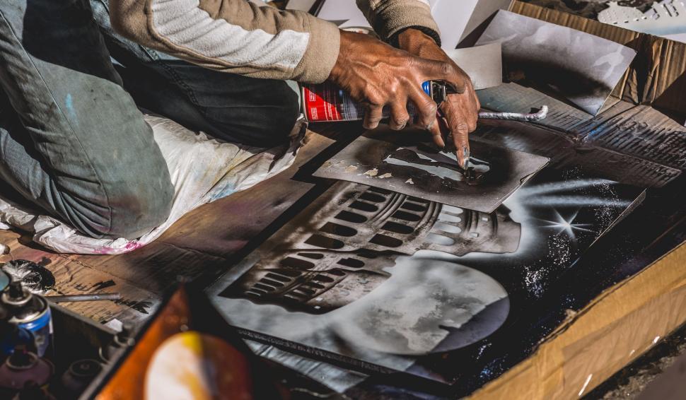 Free Image of Man Paints Picture on Table 