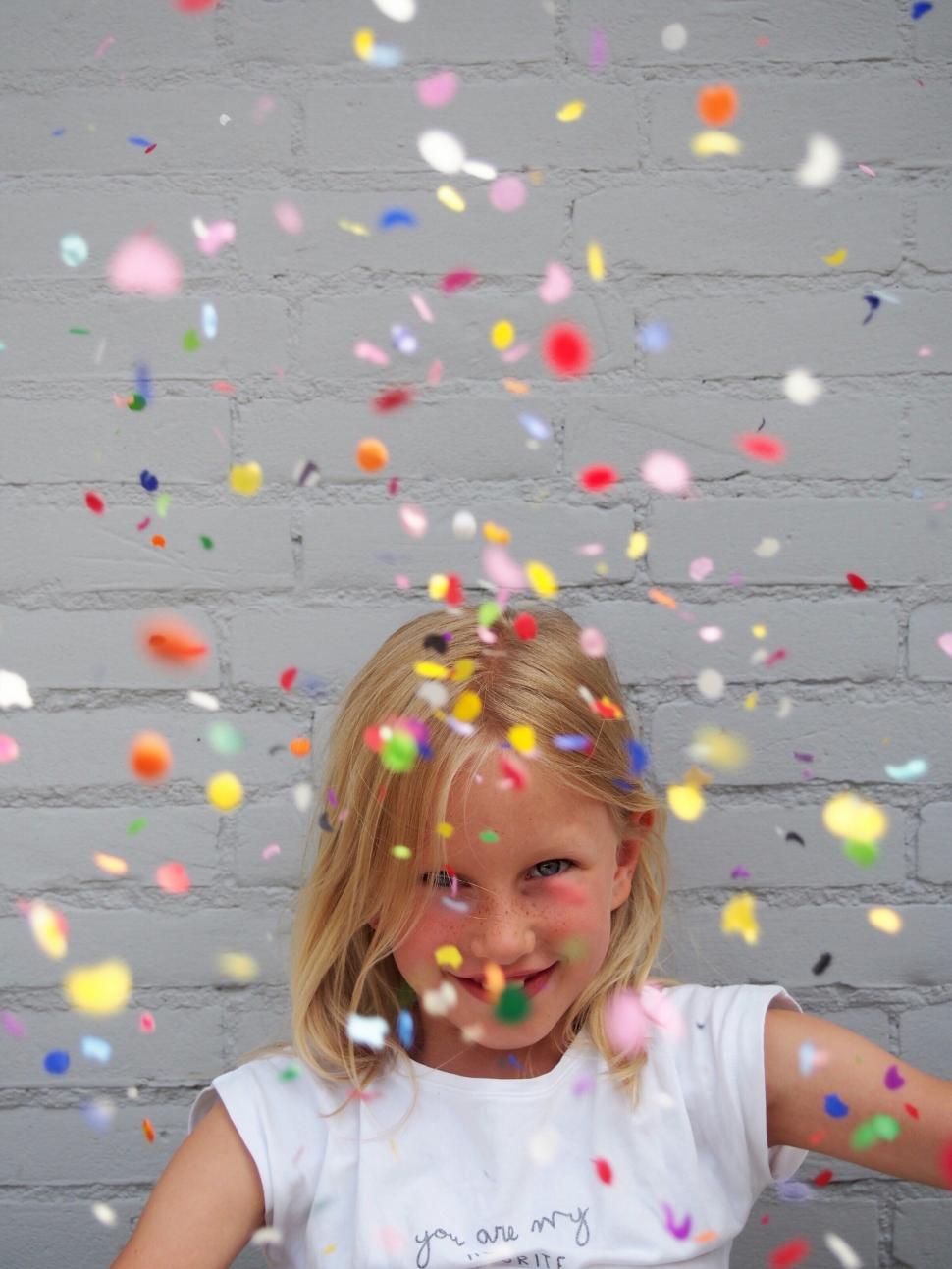 Free Image of Little Girl Standing in Front of Brick Wall 