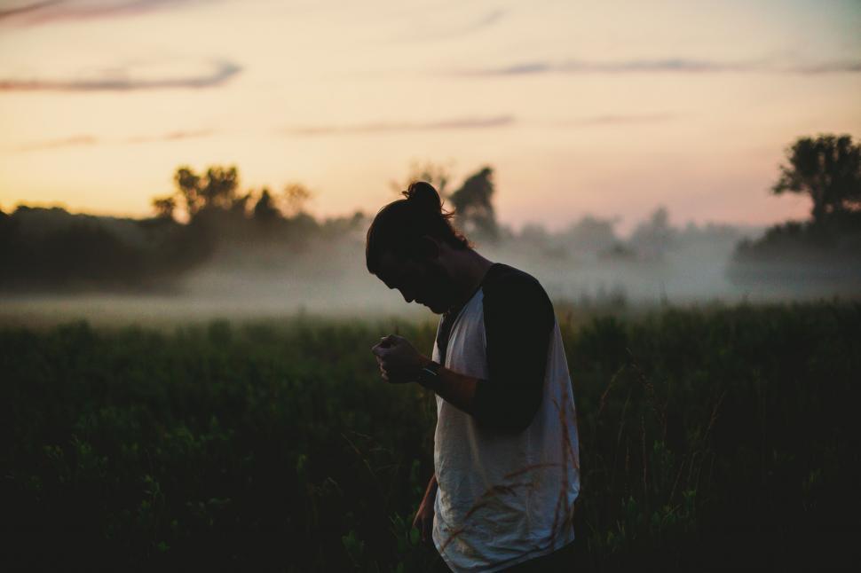 Free Image of Person Standing in Field Holding Cell Phone 