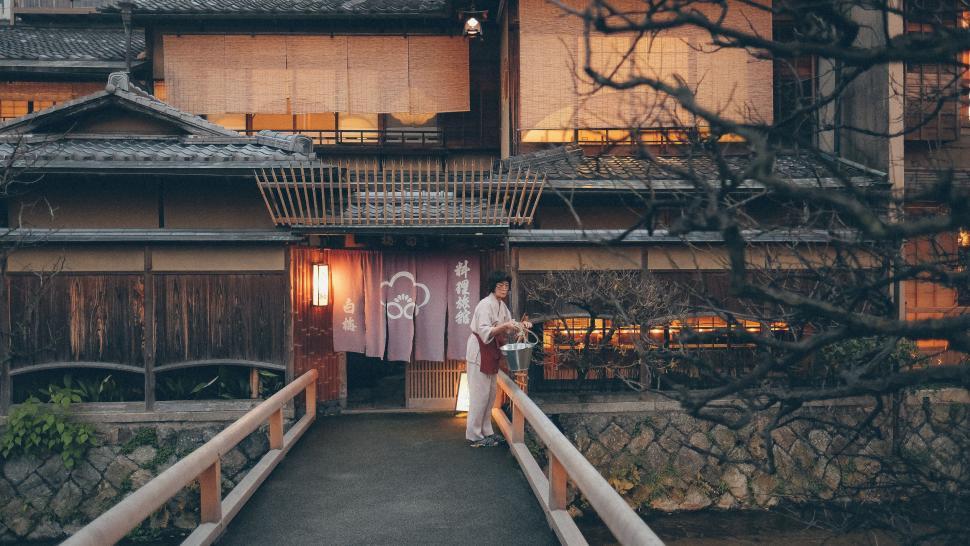 Free Image of Person Standing on Bridge in Front of Building 