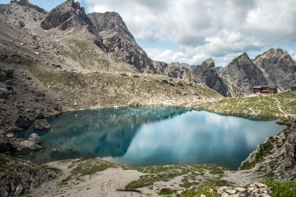 Free Image of Blue Lake Surrounded by Mountains Under Cloudy Sky 