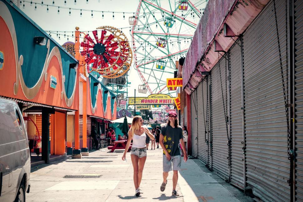 Free Image of Couple Walking Next to Ferris Wheel 