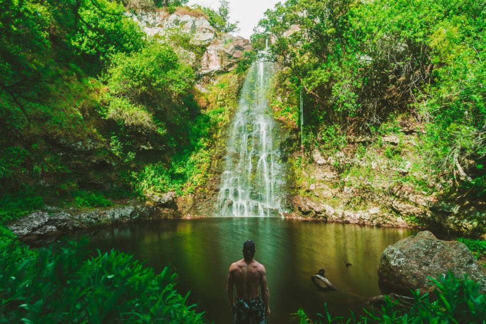 Free Image of Man Standing in Front of Waterfall 