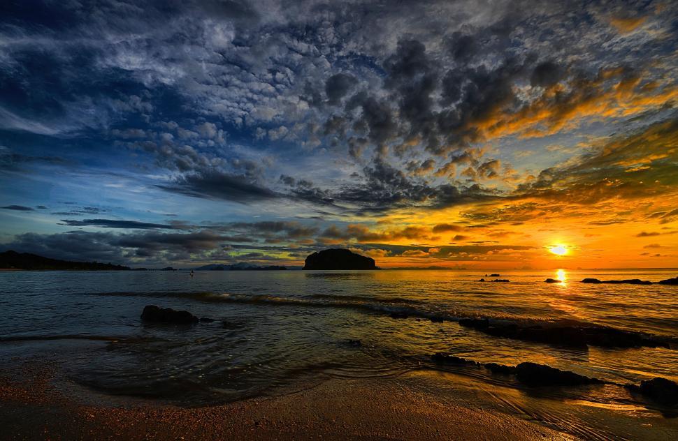 Free Image of Sun Setting Over Water at Beach 