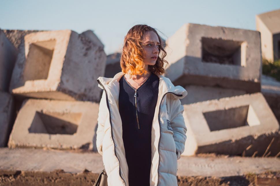 Free Image of Woman Standing in Front of Pile of Cement Blocks 