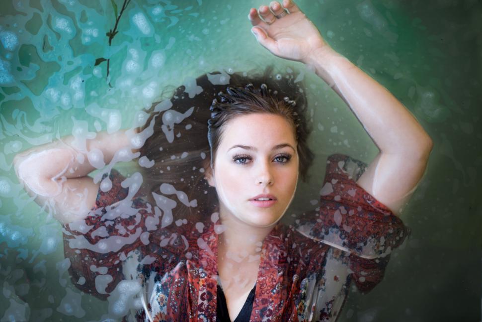 Free Image of Woman in Red and Black Shirt Holding Hands Up 