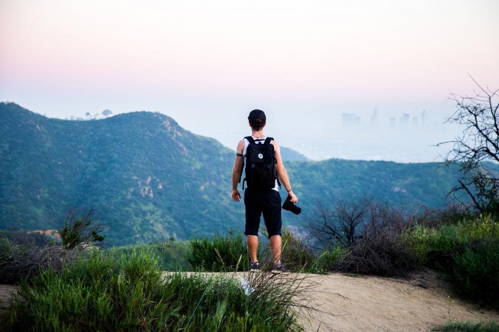 Free Image of Man Standing on Top of Lush Green Hillside 