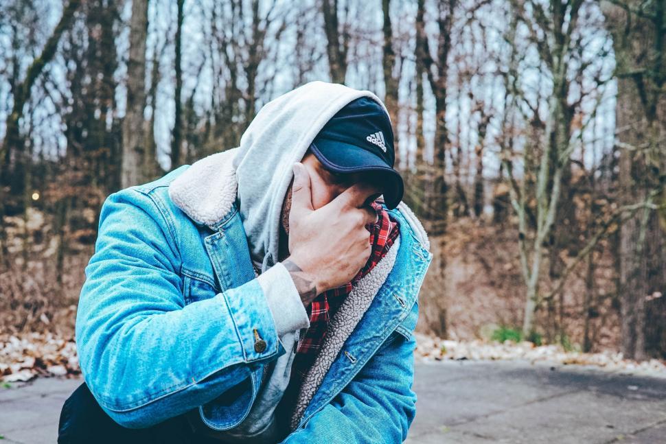 Free Image of Man in Blue Jacket Holding Hands to Face 
