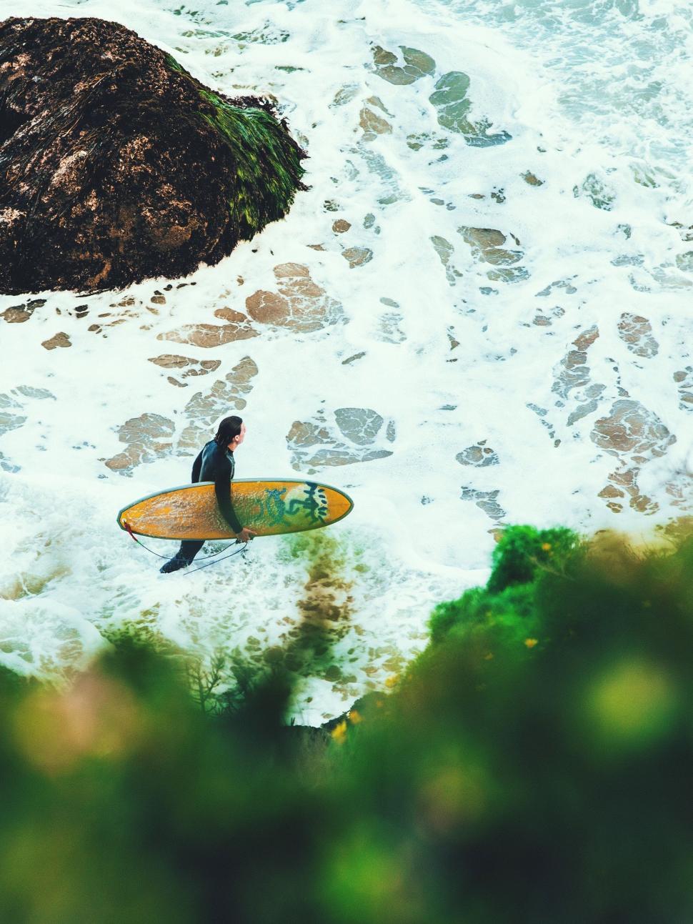 Free Image of Man Walking Into Ocean With Surfboard 
