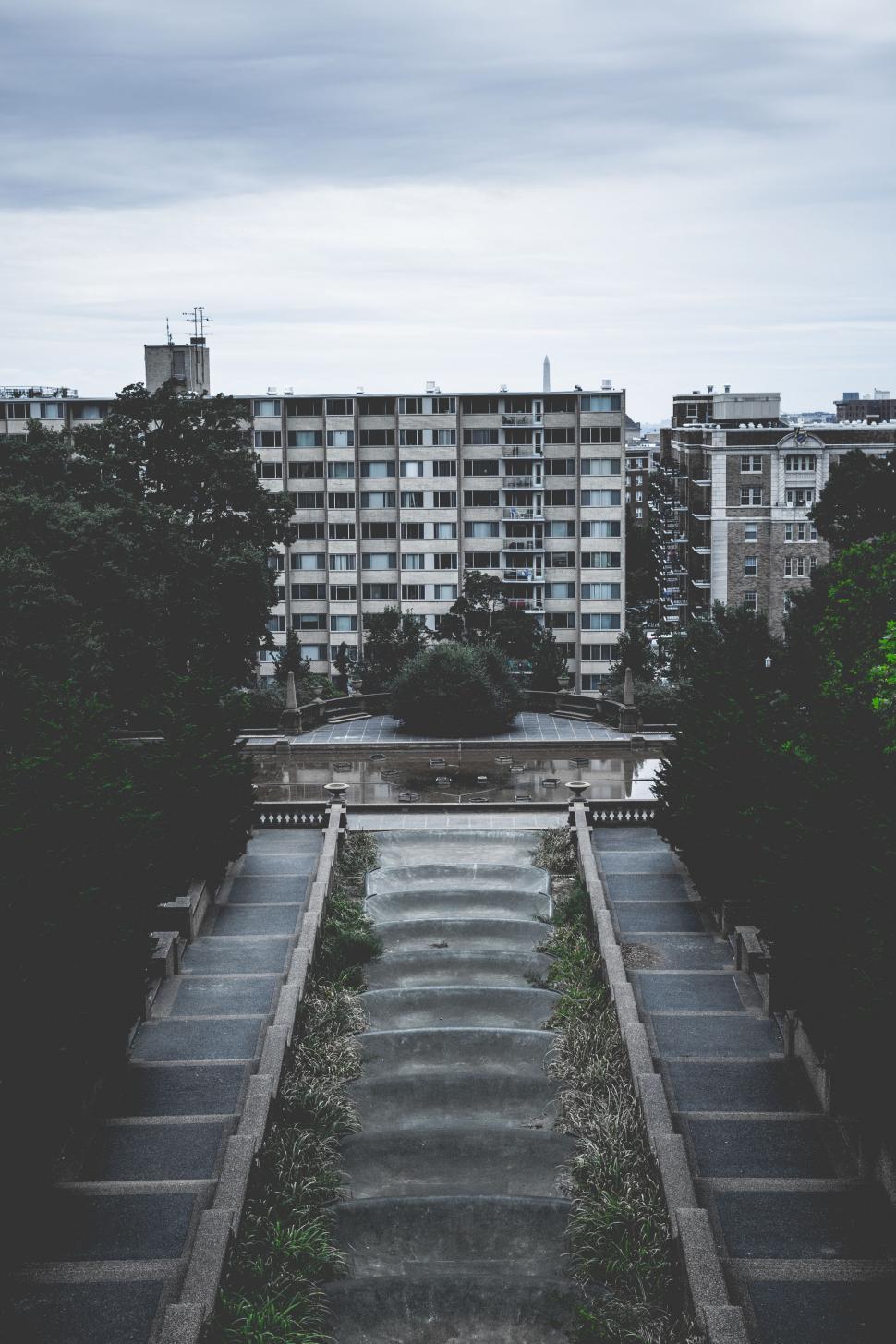 Free Image of A Black and White Photo of a Park With a Building in the Background 