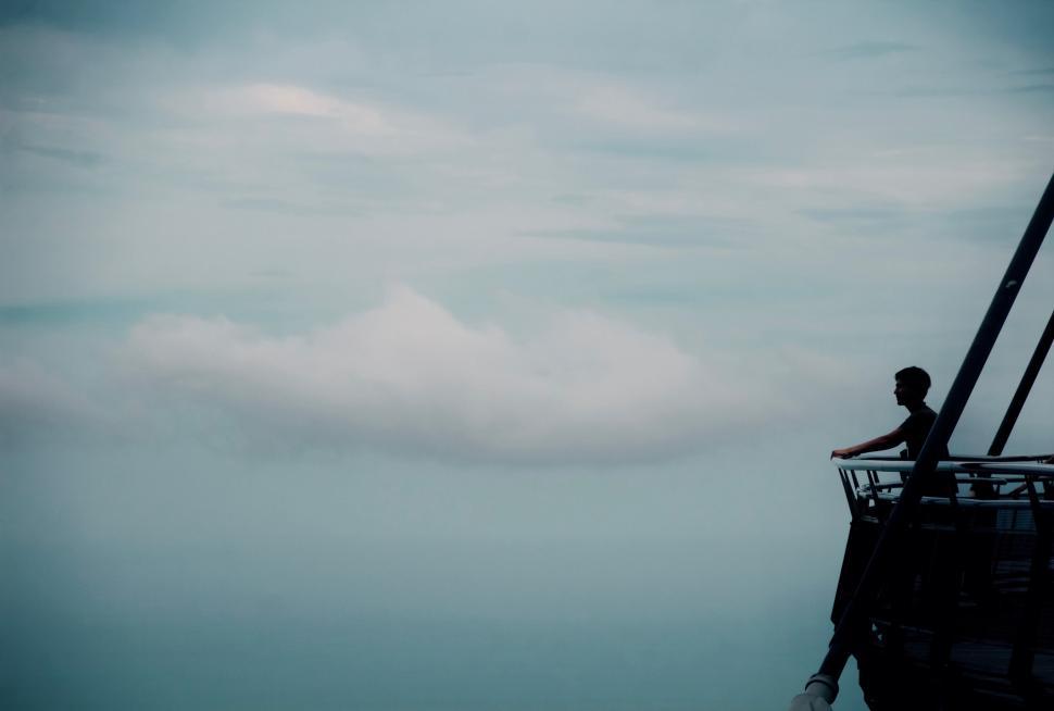 Free Image of Man Standing on Top of Boat in Ocean 