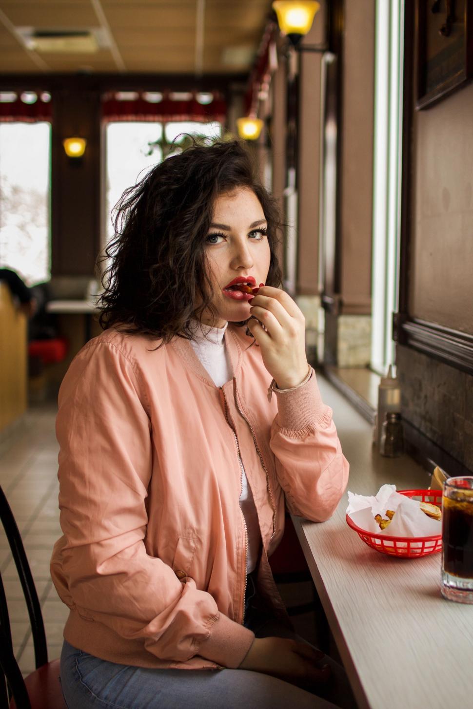 Free Image of Woman Sitting at Table Eating Food 