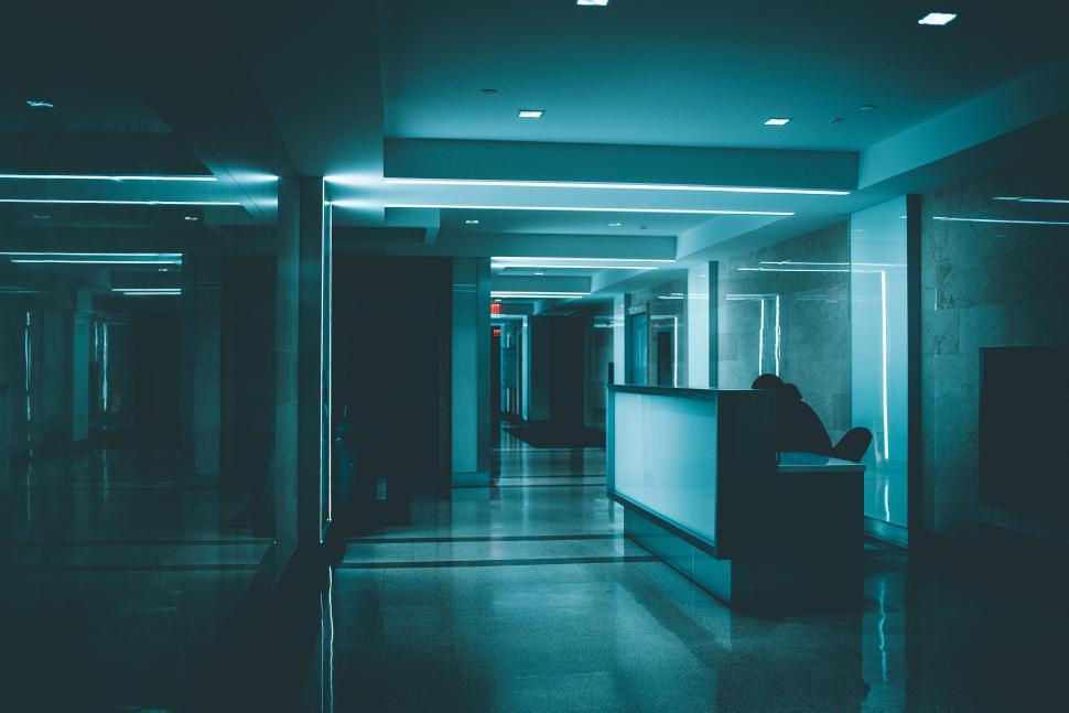 Free Image of Man Sitting on Bench in Long Hallway 