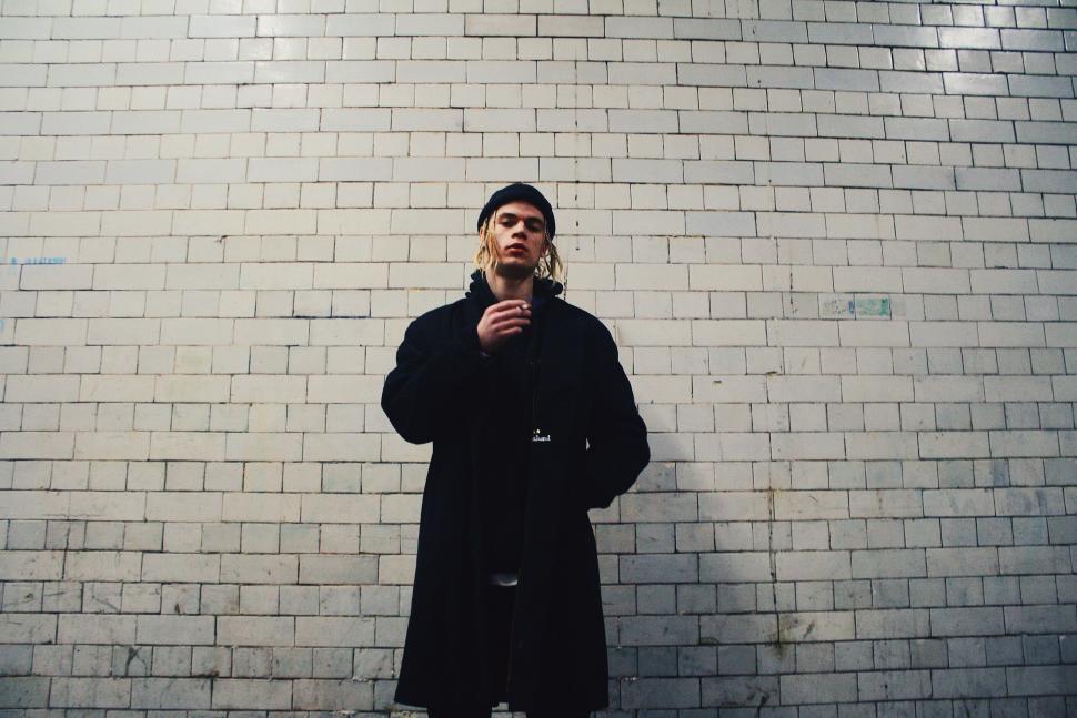 Free Image of Man Standing in Front of Brick Wall 