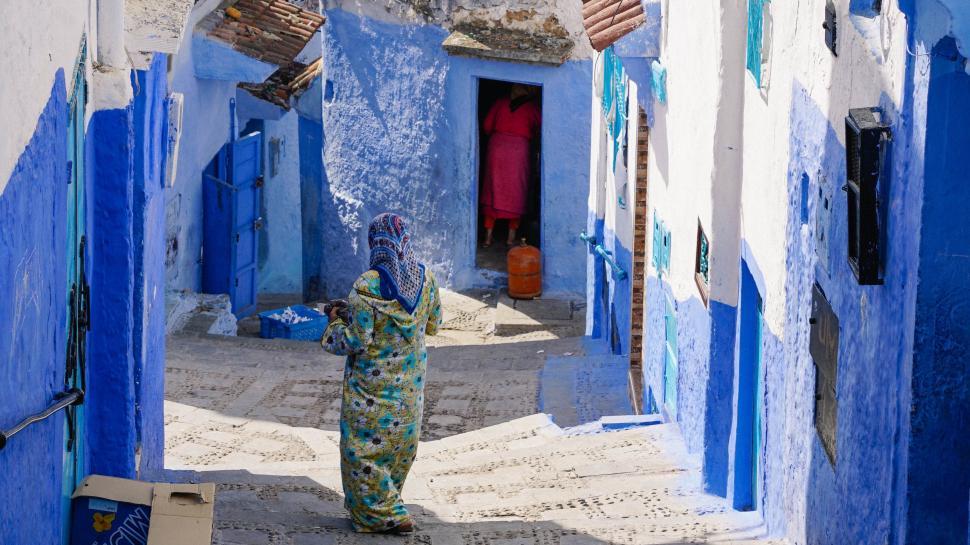 Free Image of Woman Walking Down a Narrow Alleyway 