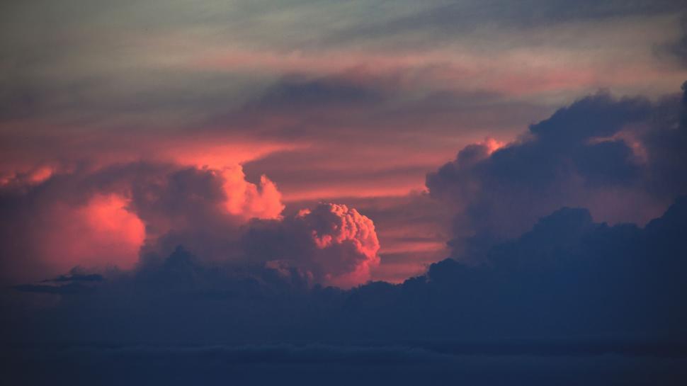 Free Image of A Plane Flying Through a Cloudy Sky at Sunset 