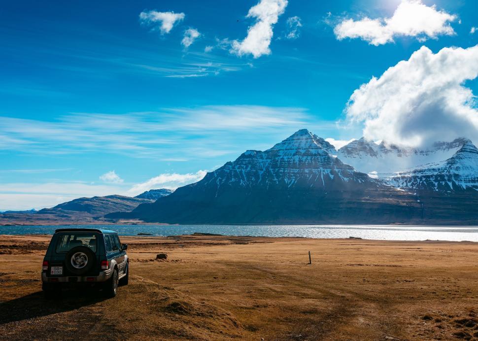 Free Image of Car Parked on Dirt Road in Front of Mountain 