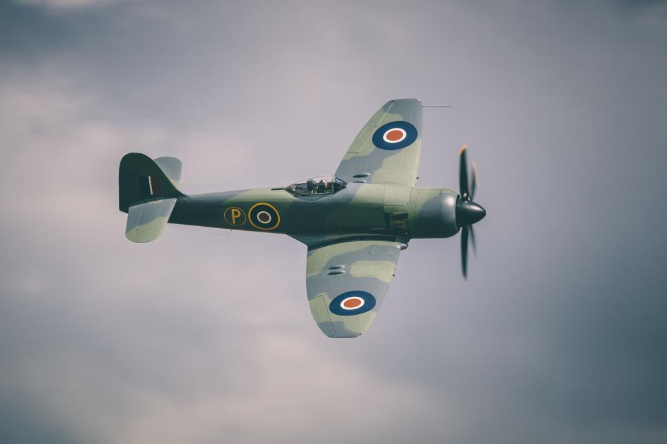 Free Image of Small Airplane Flying Through Cloudy Sky 