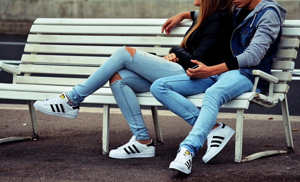 Free Image of Man and Woman Sitting on a Bench in Urban Park 