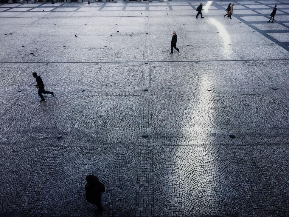 Free Image of Group of People Walking Across Tiled Floor 