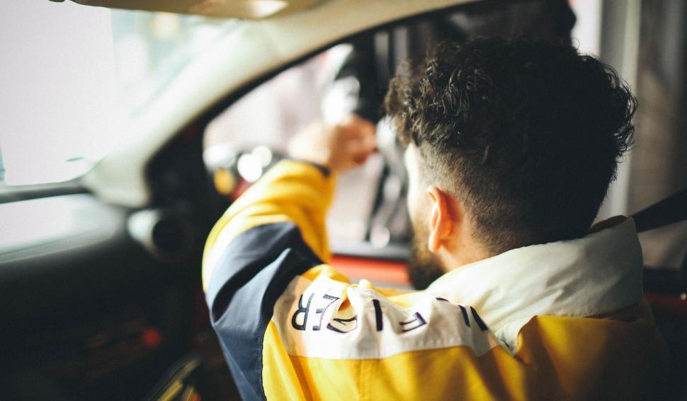 Free Image of Man Sitting in Car With Hand on Steering Wheel 