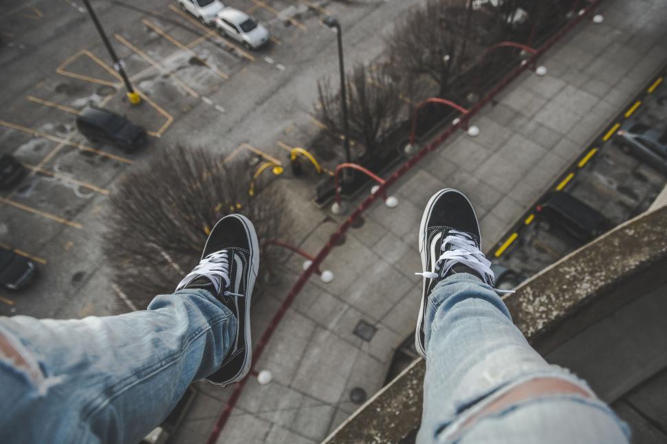 Free Image of Person Standing on Top of Building Near Parking Lot 