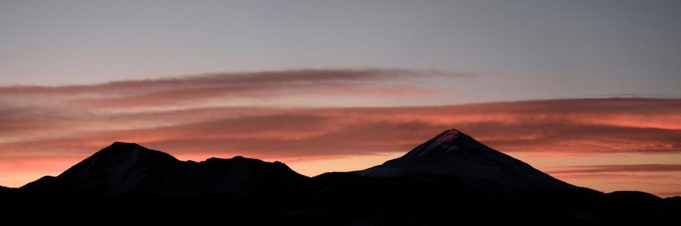 Free Image of Plane Flying Over Mountain Range at Sunset 