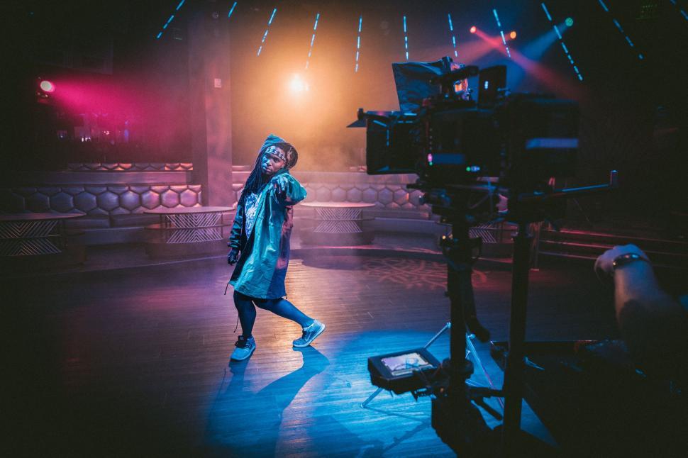 Free Image of Woman Standing on Stage in Front of Camera 