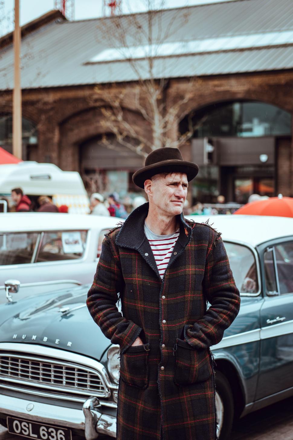 Free Image of Man Standing Next to Car in Parking Lot 
