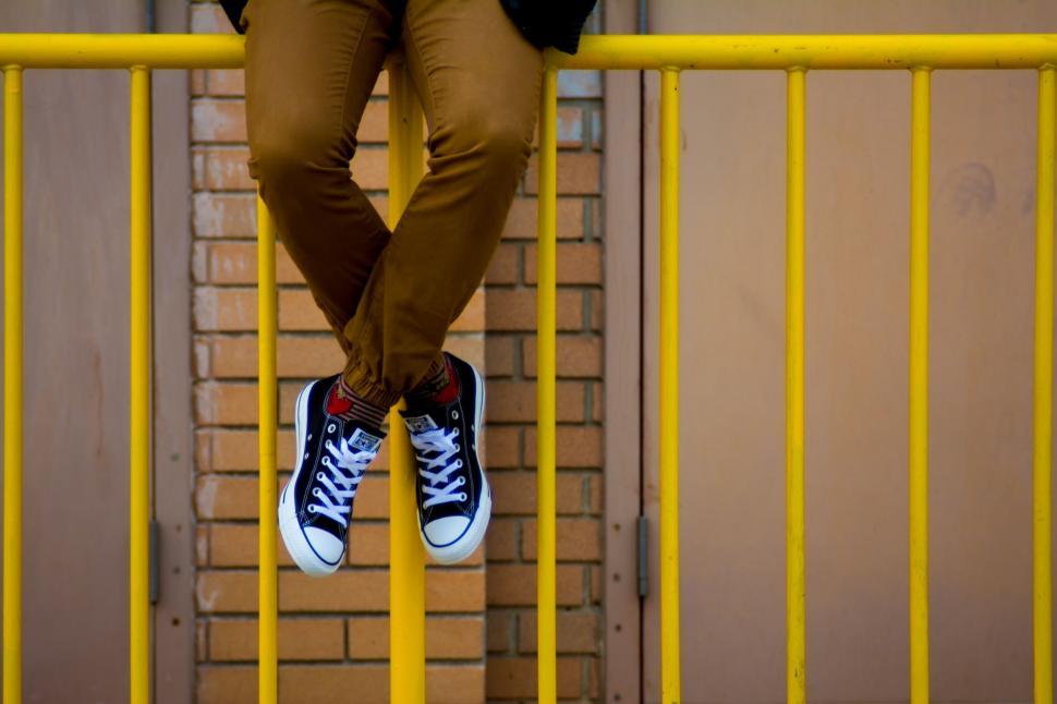 Free Image of Man Sitting on Yellow Railing 