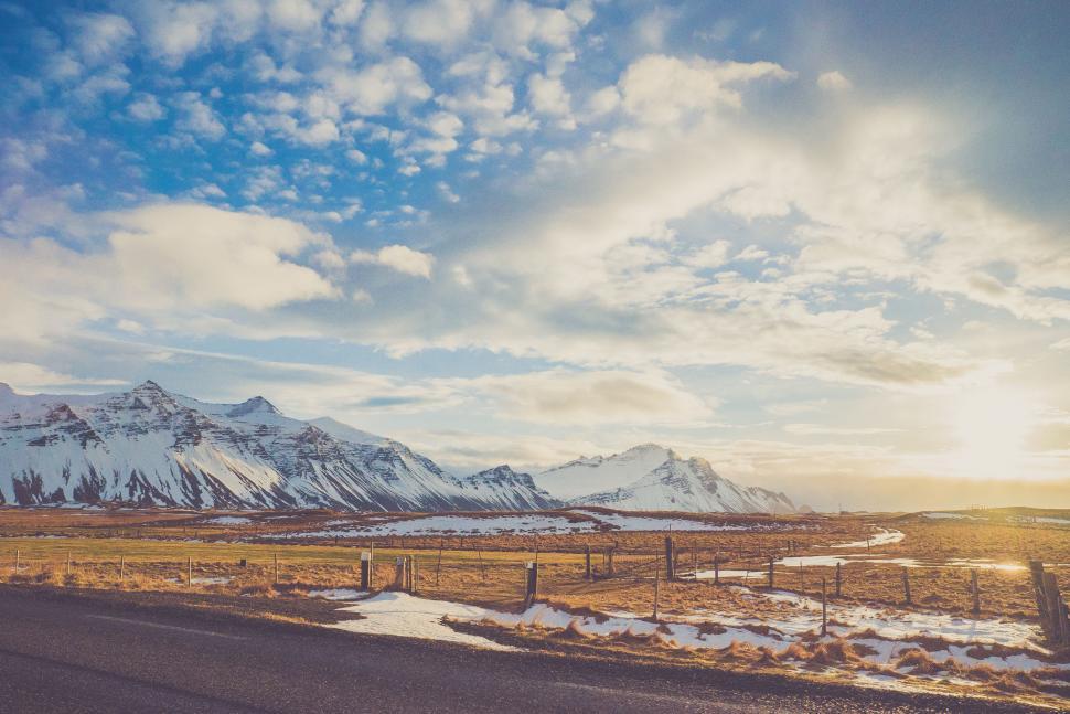 Free Image of Car Driving Down Road With Mountains in Background 