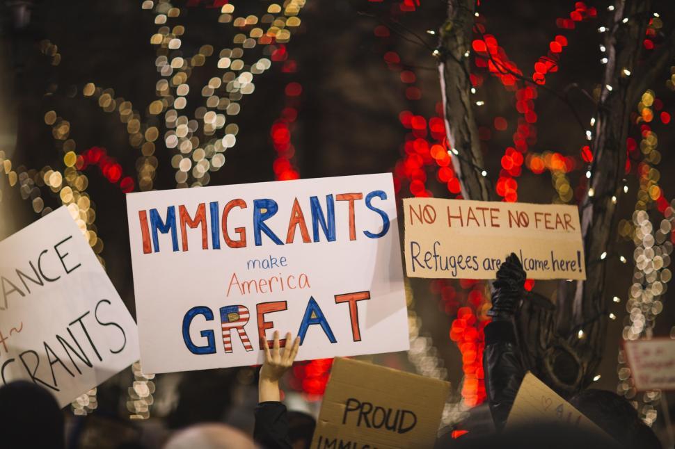 Free Image of Group of People Holding Signs in Front of a Christmas Tree 