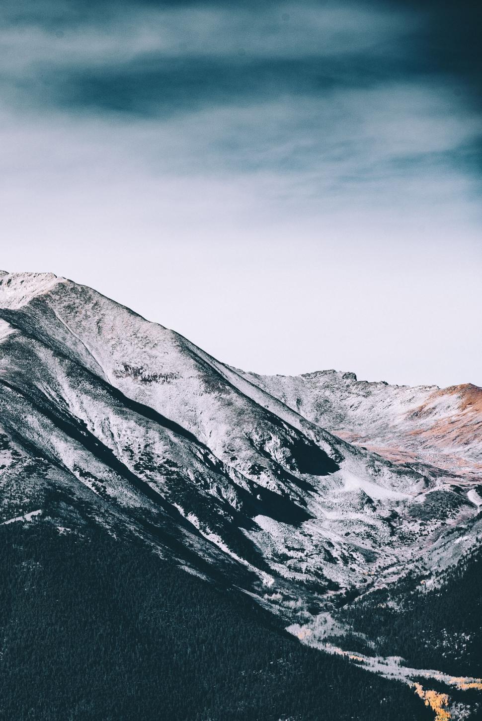 Free Image of Snow Covered Mountain Range Under Cloudy Sky 