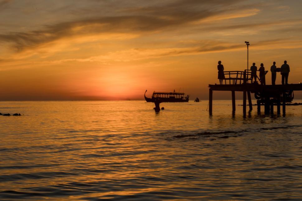 Free Image of Group of People Standing on Top of a Pier 