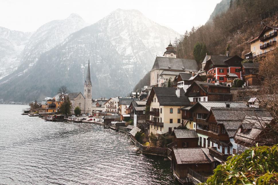 Free Image of Village on the Shore of Lake With Mountains in Background 