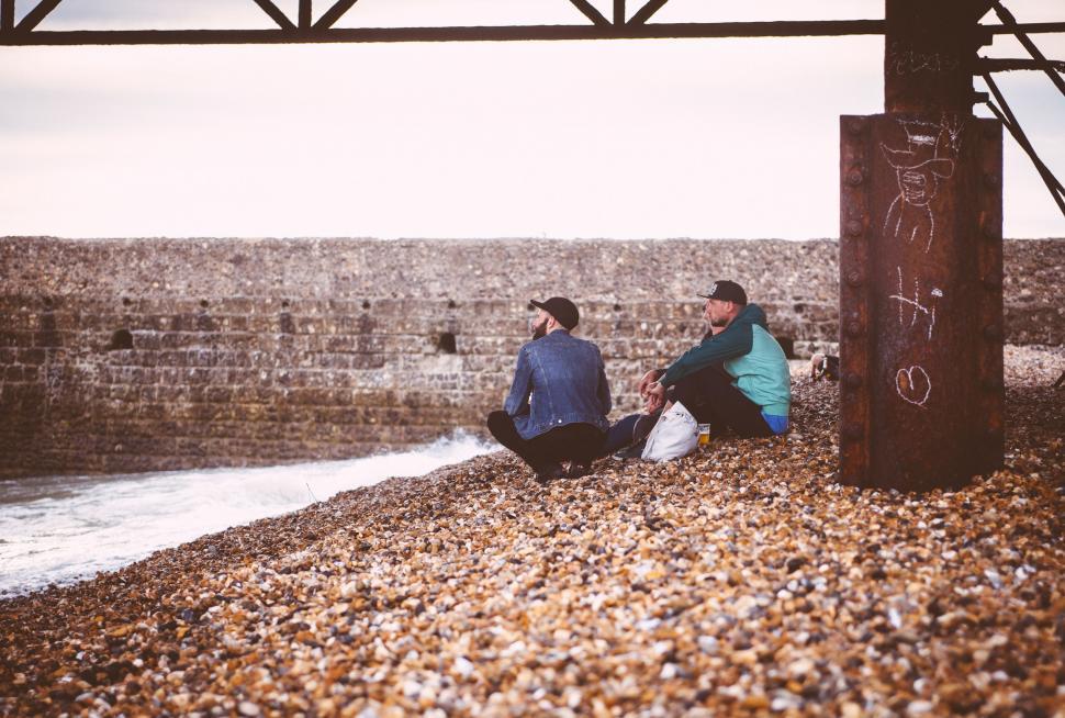 Free Image of Couple Sitting on Top of a Beach 