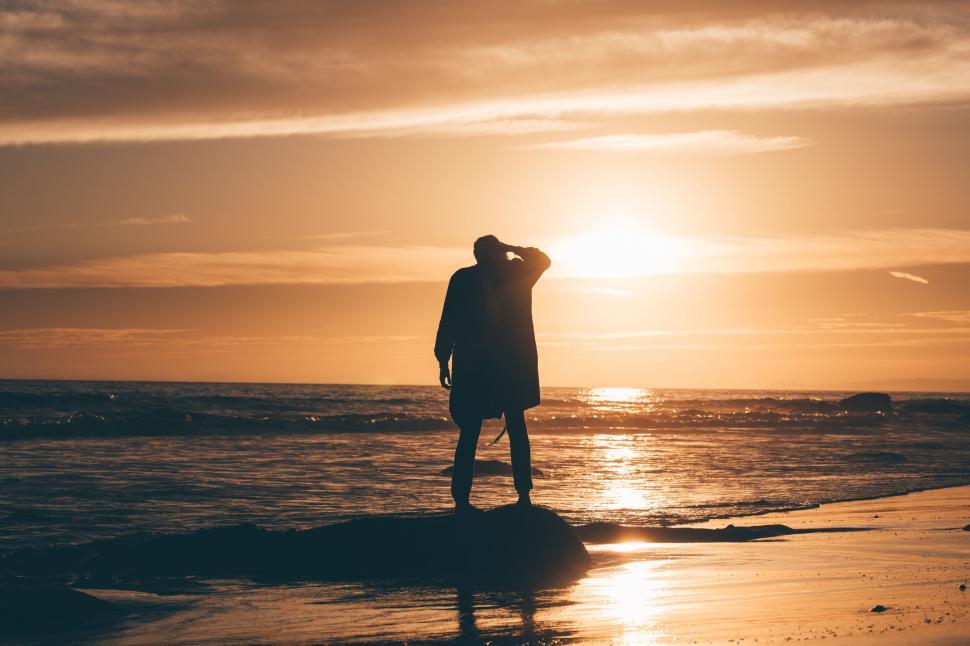 Free Image of Person Standing on Beach at Sunset 