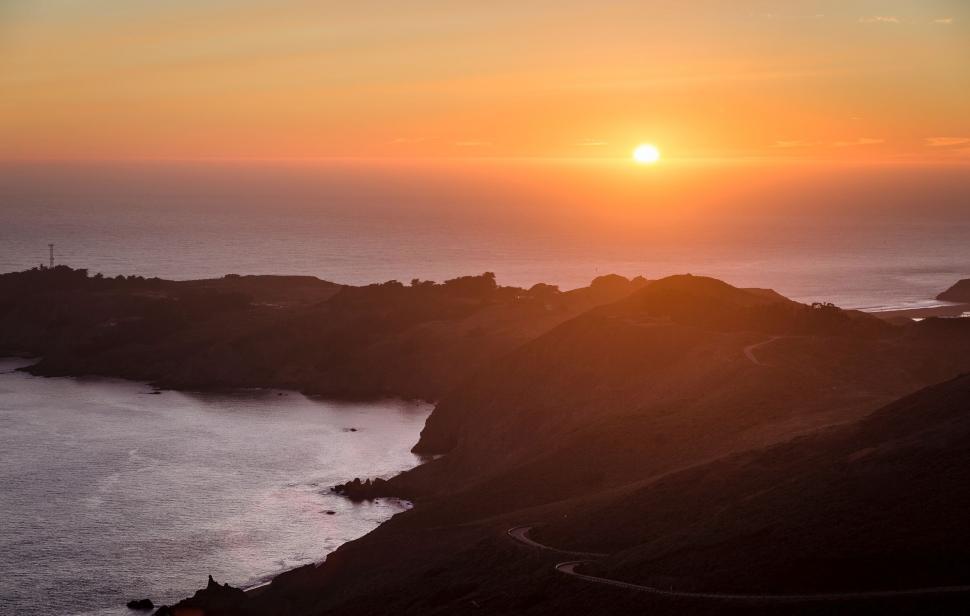 Free Image of Sun Setting Over Body of Water 