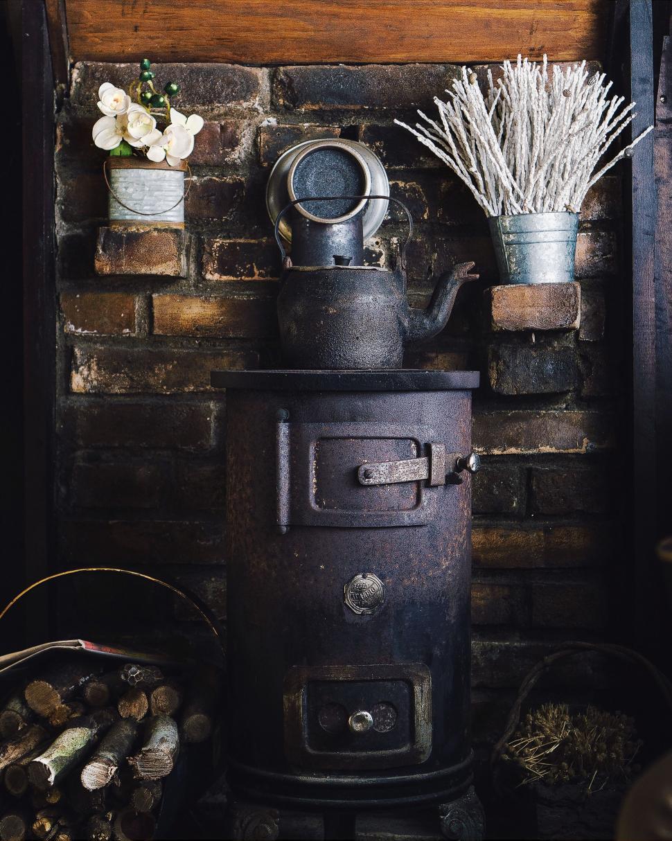 Free Image of Black Stove Next to Pile of Logs 