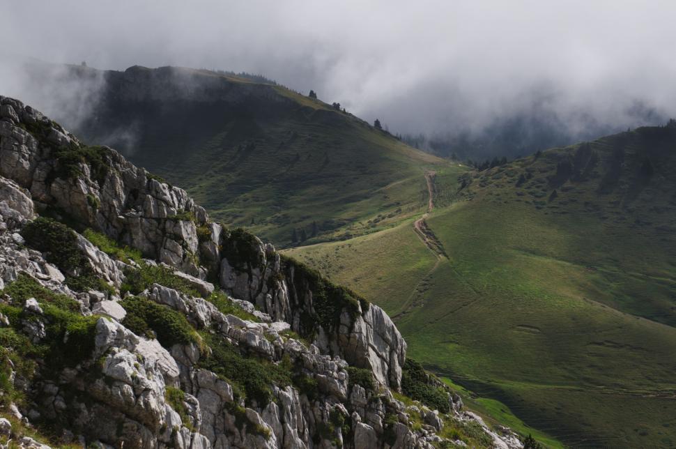 Free Image of Clouds Rolling Over Mountain Side 