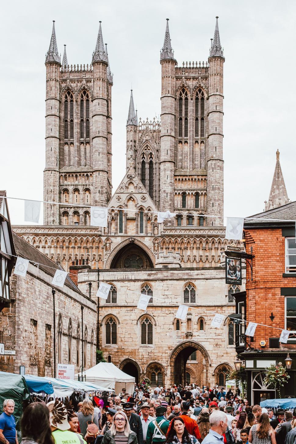 Free Image of Busy Crowd Walking Around Historic Cathedral 