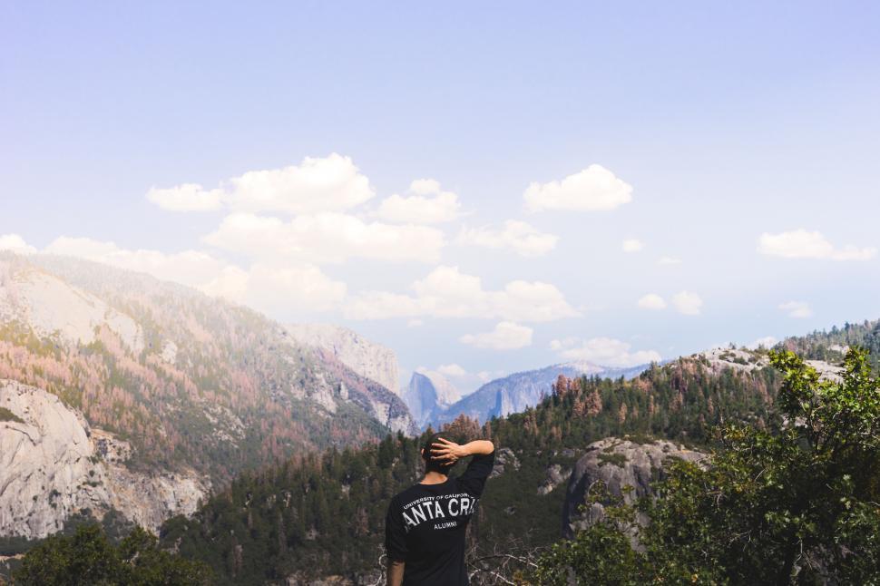 Free Image of Man Standing on Top of Lush Green Hillside 