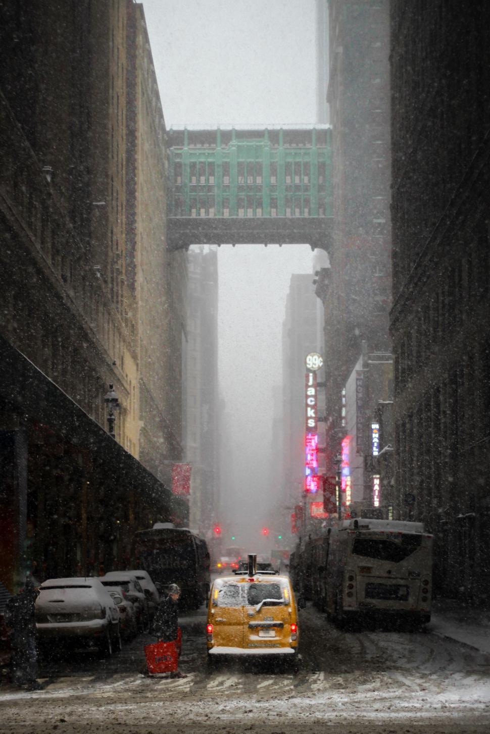 Free Image of Yellow Taxi Cab Driving Down Snow Covered Street 