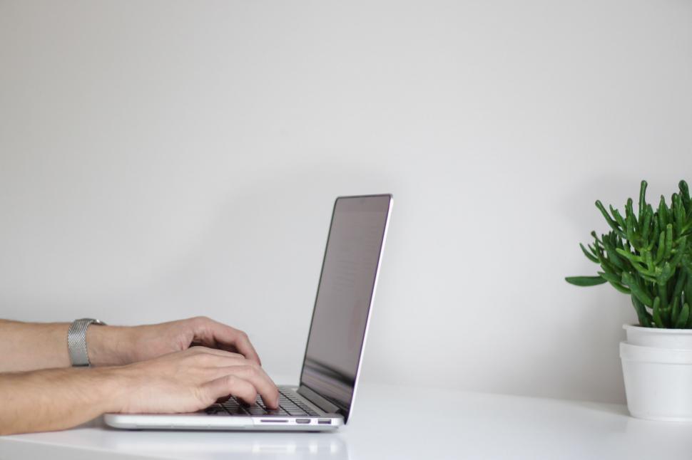 Free Image of Man Typing on Laptop at Desk 