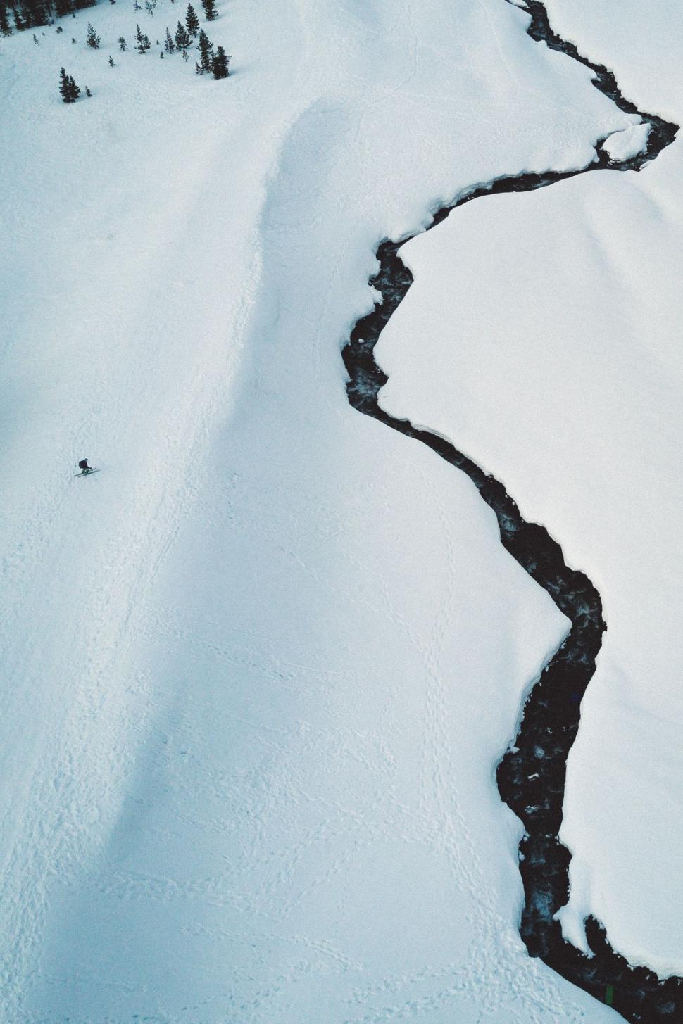 Free Image of Man Riding Skis Down Snow Covered Slope 