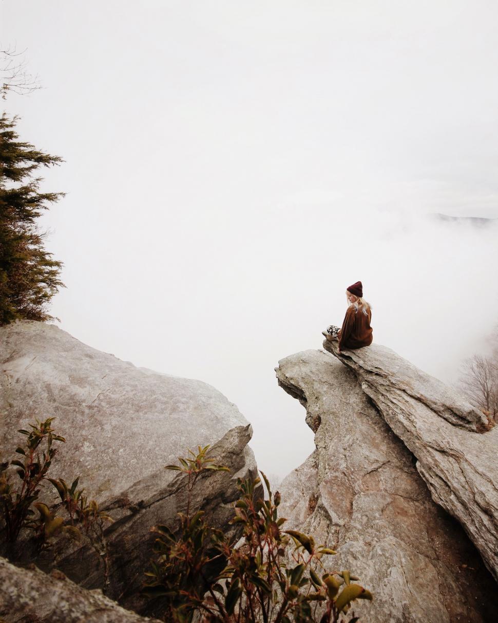 Free Image of Person Sitting on Rock by Water 