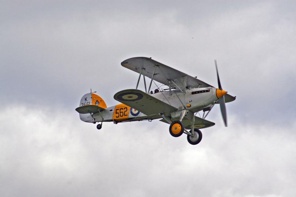 Free Image of Small Airplane Flying Through Cloudy Sky 