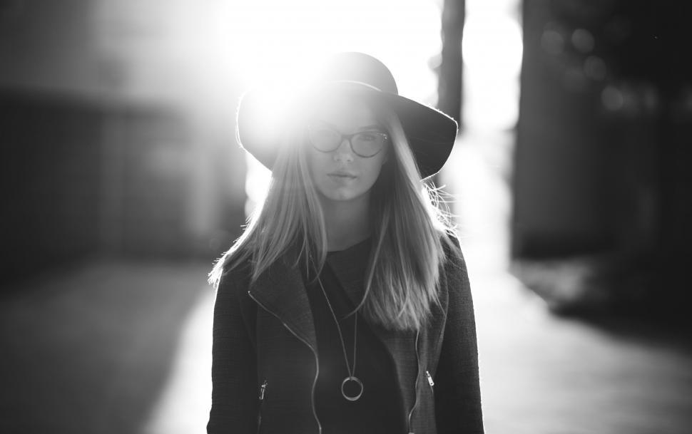 Free Image of Woman Walking Down a Street With a Hat On 